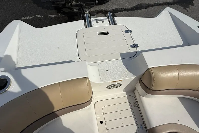 Slide: The Image of 2014 Starcraft Crossover 210 SCX OB boat interior with beige seating and storage compartment. - 15