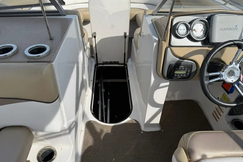 Slide: The Image of 2014 Starcraft Crossover 210 SCX OB boat interior with steering wheel and storage compartment. - 17