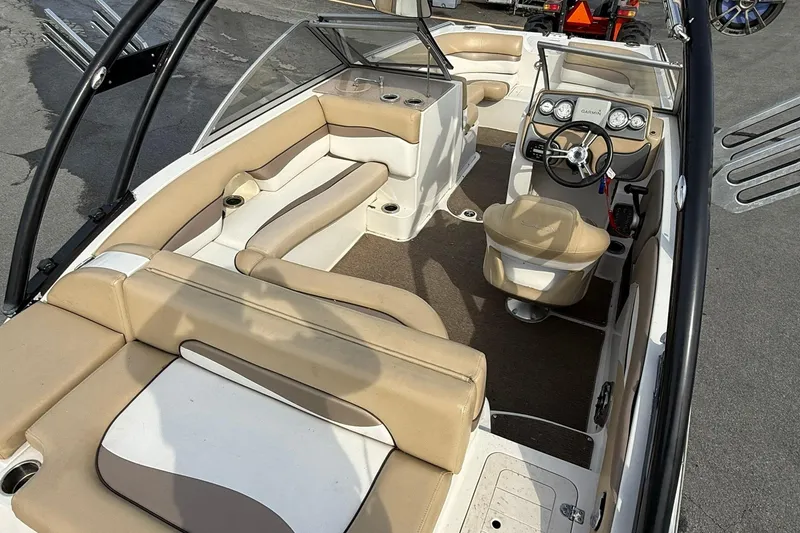 Slide: The Image of 2014 Starcraft Crossover 210 SCX OB boat interior with beige seating and steering console. - 6