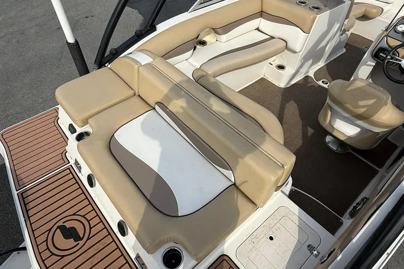 Slide: The Image of 2014 Starcraft Crossover 210 SCX OB boat interior with beige seating and wood accents. - 7