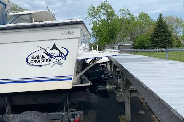Slide: The Image of 2007 Baha Cruisers 251 GLE boat on trailer near dock, showcasing logo and outboard motor. - 10