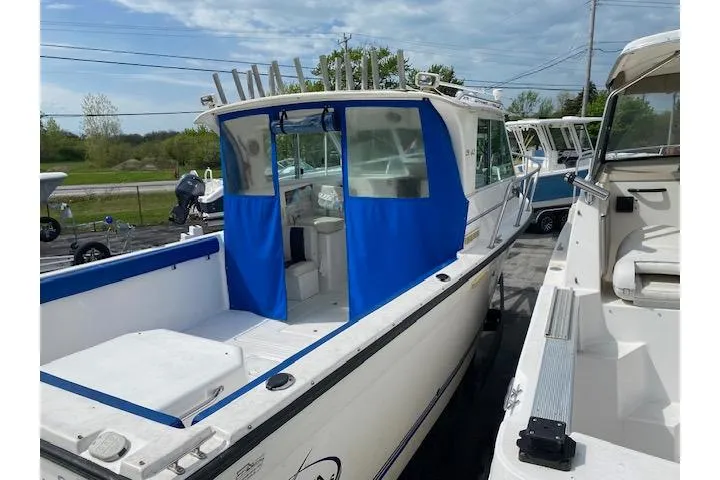 Slide: The Image of 2007 Baha Cruisers 251 GLE boat with blue canopy, docked outdoors. - 6