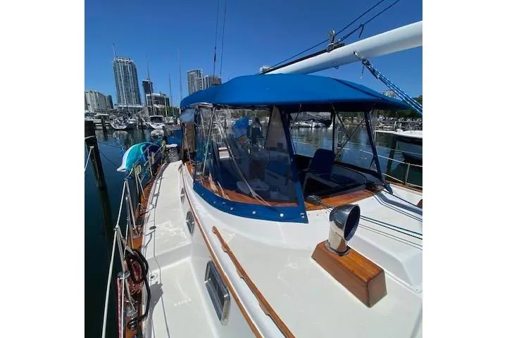 Slide: The Image of 1982 Endeavour 40 sailboat docked at marina with blue canopy and city skyline. - 12