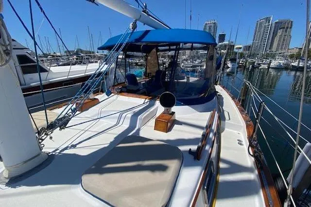 Slide: The Image of 1982 Endeavour 40 sailboat docked in marina with blue canopy and city skyline. - 13