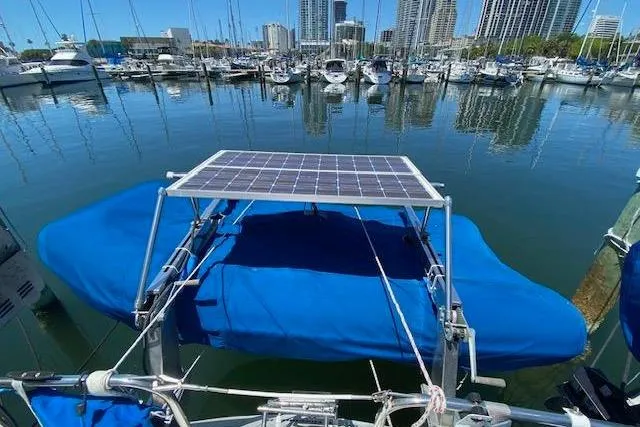 Slide: The Image of Sailboat with solar panel, Endeavour 40, 1982, docked in marina with city skyline. - 16