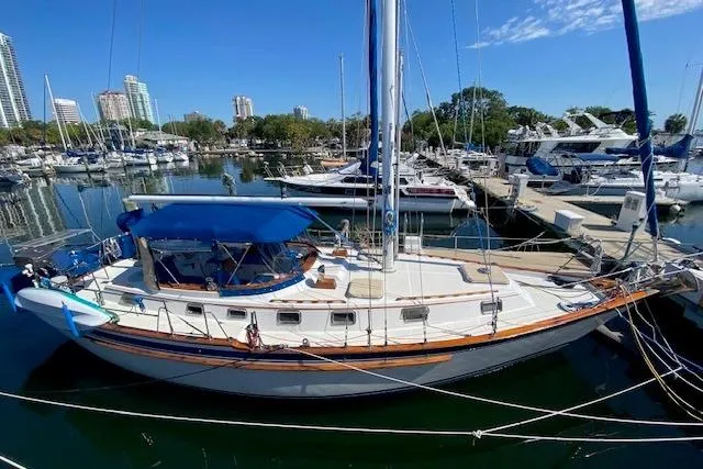 Slide: The Image of 1982 Endeavour 40 sailboat docked in a marina, surrounded by other boats and cityscape. - 2