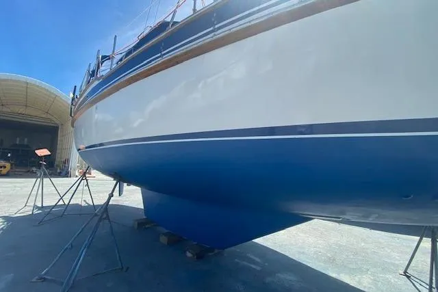 Slide: The Image of 1982 Endeavour 40 sailboat on stands, showcasing its sleek blue and white hull. - 29