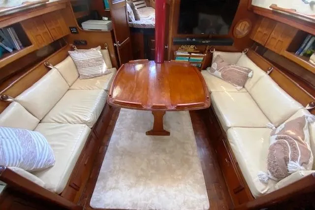 Slide: The Image of Cozy interior of 1982 Endeavour 40 sailboat with wooden table and cushioned seating. - 32