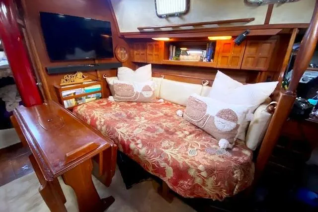 Slide: The Image of Cozy 1982 Endeavour 40 sailboat interior with floral sofa, pillows, and wooden accents. - 34