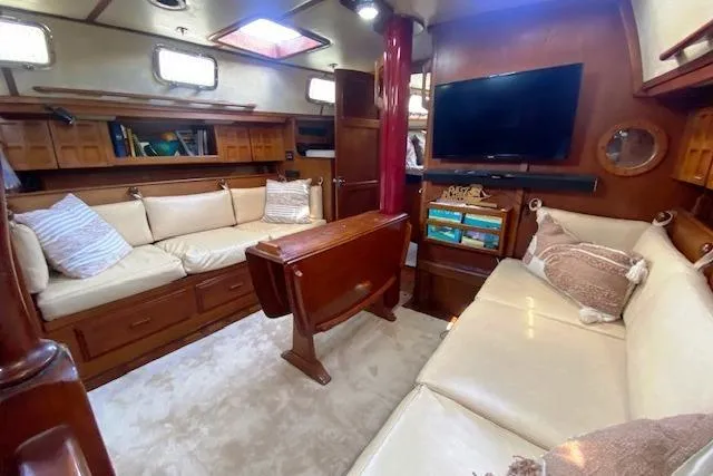 Slide: The Image of Cozy interior of 1982 Endeavour 40 sailboat with sofas, TV, and wooden accents. - 36