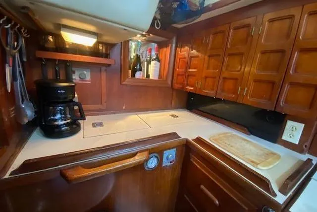 Slide: The Image of 1982 Endeavour 40 yacht kitchen with wooden cabinets, coffee maker, and countertop. - 39
