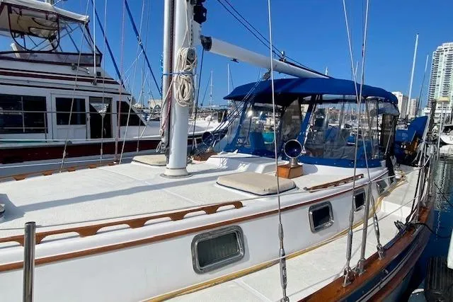 Slide: The Image of 1982 Endeavour 40 sailboat docked at marina, featuring blue canopy and wooden accents. - 4