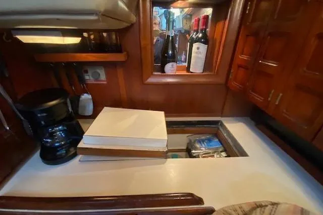 Slide: The Image of 1982 Endeavour 40 yacht galley with wine bottles, coffee maker, and storage space. - 40