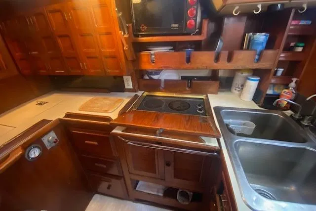 Slide: The Image of 1982 Endeavour 40 yacht kitchen with wooden cabinetry, stove, and double sink. - 41