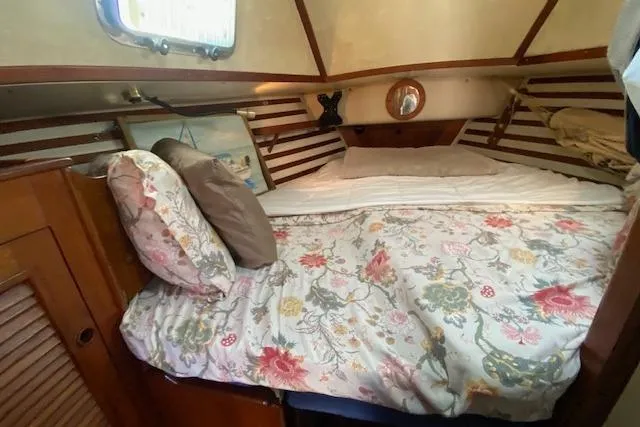 Slide: The Image of Cozy cabin interior of 1982 Endeavour 40 sailboat with floral bedding and wooden accents. - 43