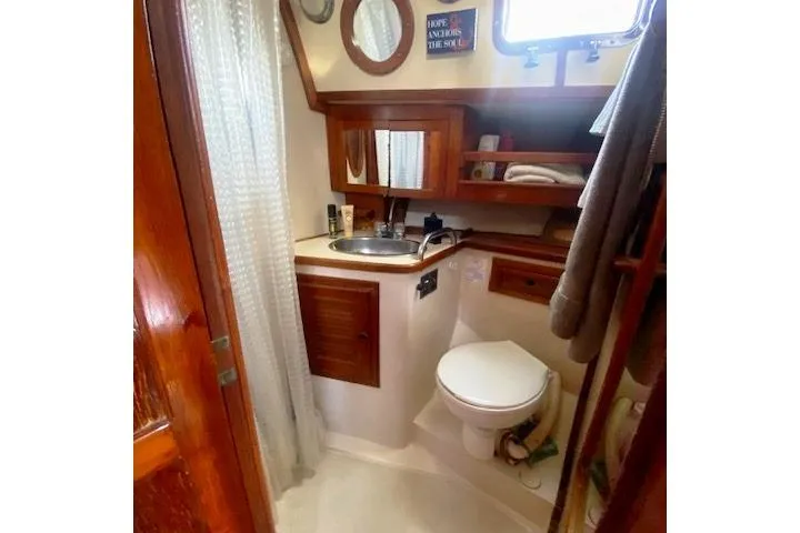 Slide: The Image of 1982 Endeavour 40 yacht bathroom with wooden cabinets, sink, and toilet. - 45