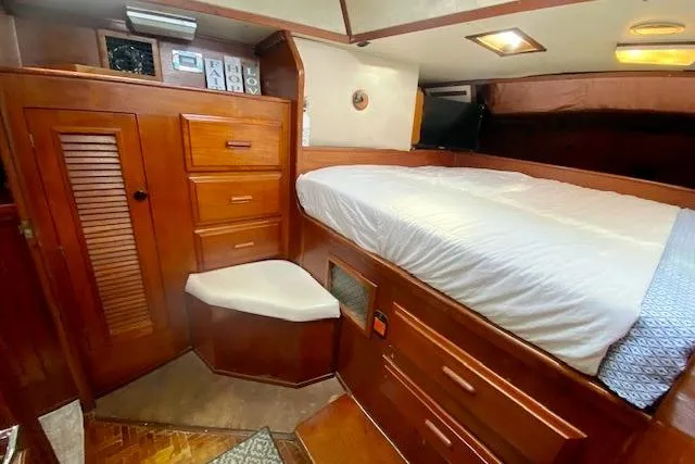 Slide: The Image of Cozy 1982 Endeavour 40 yacht cabin with wooden cabinetry and comfortable bedding. - 53
