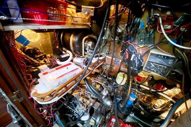 Slide: The Image of Engine room of a 1982 Endeavour 40 sailboat, showcasing complex wiring and mechanical components. - 60