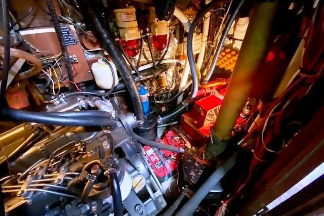 Slide: The Image of Engine room of a 1982 Endeavour 40 sailboat, showcasing complex machinery and wiring. - 61