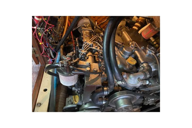 Slide: The Image of Engine compartment of a 1982 Endeavour 40 sailboat, showcasing mechanical components and wiring. - 63