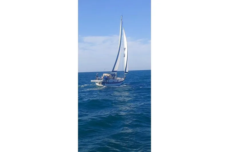Slide: The Image of Sailboat Endeavour 40, 1982 model, cruising on open sea under clear blue skies. - 69