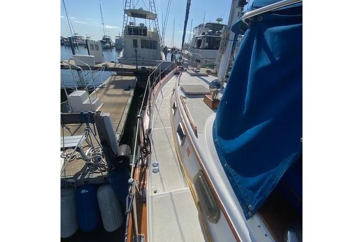 Slide: The Image of 1982 Endeavour 40 sailboat docked at marina, featuring deck view and blue canvas cover. - 7