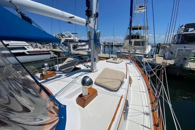 Slide: The Image of 1982 Endeavour 40 sailboat docked at marina, featuring deck cushions and rigging. - 9