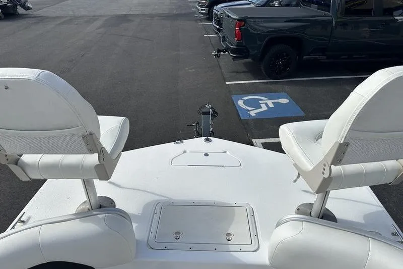 Slide: The Image of 2026 Hurricane FunDeck 196 RE boat with white seating, parked near a handicap space. - 13