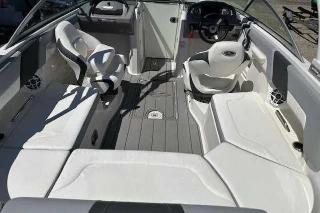 Slide: The Image of 2023 Chaparral 23 SSi boat interior with white seating and modern dashboard design. - 20