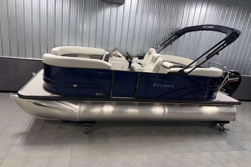 The Image of 2026 Sylvan Mirage 8520 LZ PTS Tritoon boat in showroom, featuring sleek design and comfortable seating. - 0