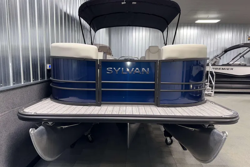 Slide: The Image of 2026 Sylvan Mirage 8520 LZ PTS Tritoon in showroom, featuring sleek blue design and canopy. - 17