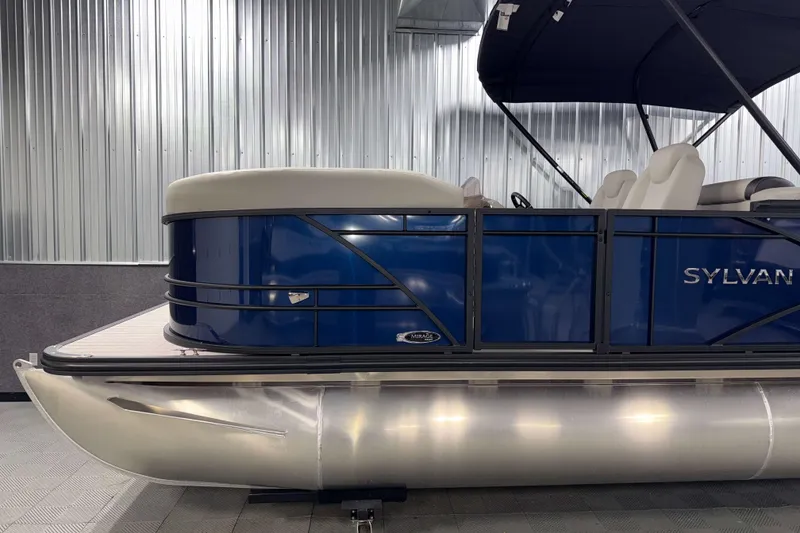 Slide: The Image of 2026 Sylvan Mirage 8520 LZ PTS Tritoon boat with blue exterior in showroom. - 19