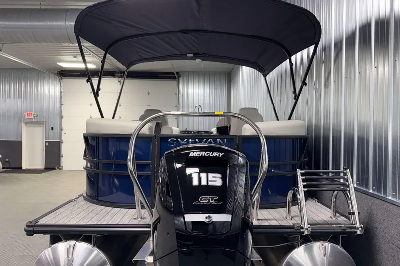 Slide: The Image of 2026 Sylvan Mirage 8520 LZ PTS Tritoon with Mercury 115 engine in a garage. - 23