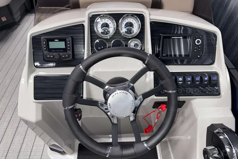 Slide: The Image of 2026 Sylvan Mirage 8520 LZ PTS Tritoon dashboard with steering wheel and control panel. - 8