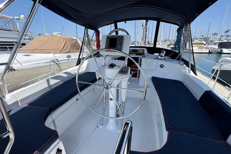 Slide: The Image of 2004 Hunter 41 Aft Cockpit sailboat interior with steering wheel and navigation equipment. - 10