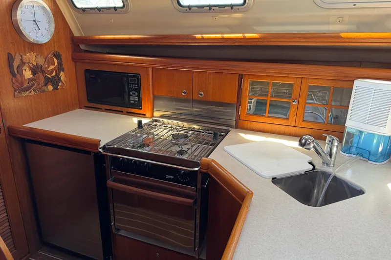 Slide: The Image of Galley kitchen in 2004 Hunter 41 Aft Cockpit sailboat with stove, sink, and microwave. - 28