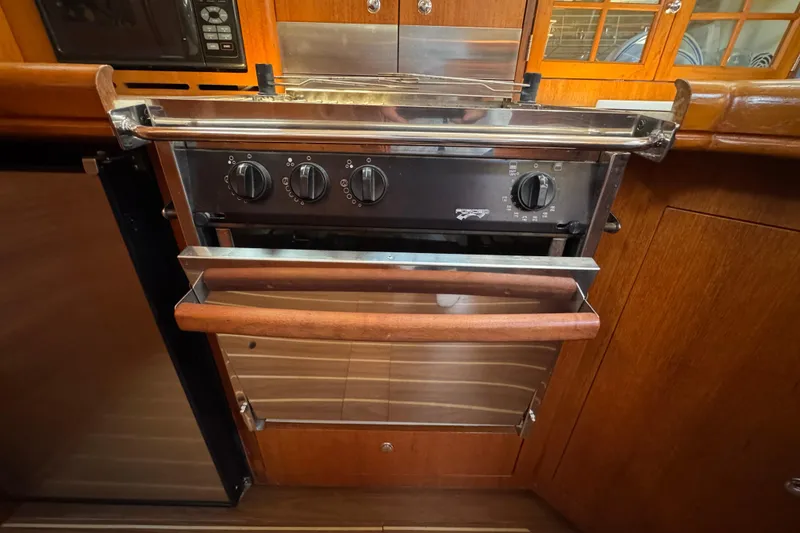Slide: The Image of 2004 Hunter 41 Aft Cockpit yacht kitchen with stainless steel oven and wooden cabinetry. - 29