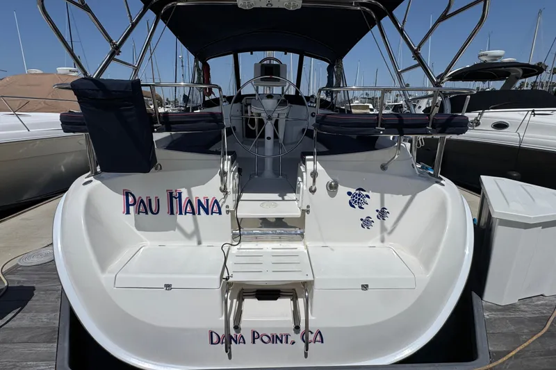Slide: The Image of 2004 Hunter 41 Aft Cockpit sailboat docked, featuring "Pau Hana" name and turtle decals. - 4
