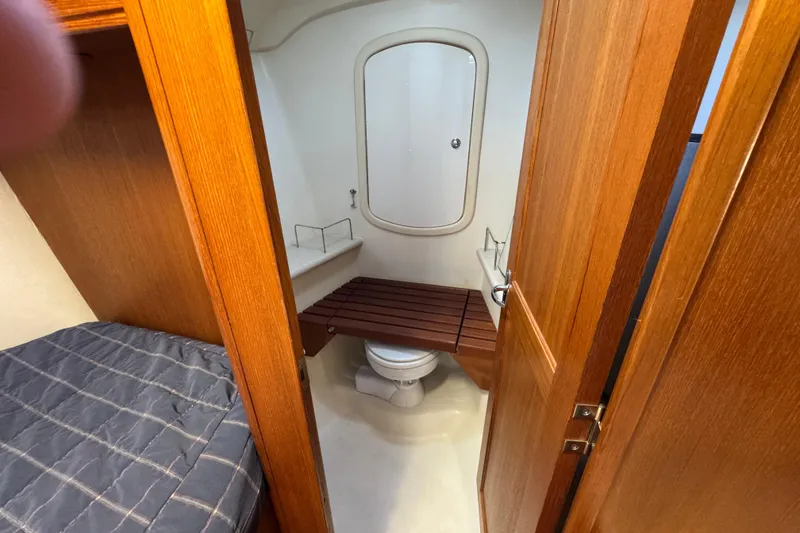 Slide: The Image of 2004 Hunter 41 Aft Cockpit yacht bathroom with wooden accents and compact design. - 48