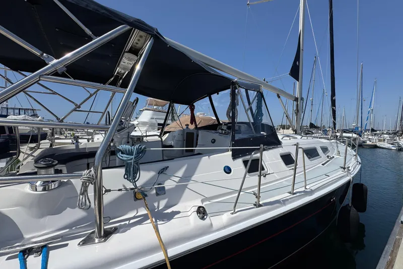 Slide: The Image of 2004 Hunter 41 Aft Cockpit sailboat docked in a marina under clear blue skies. - 5