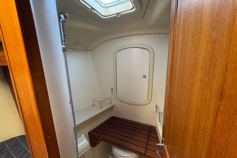 Slide: The Image of 2004 Hunter 41 Aft Cockpit bathroom with wooden accents and overhead skylight. - 50