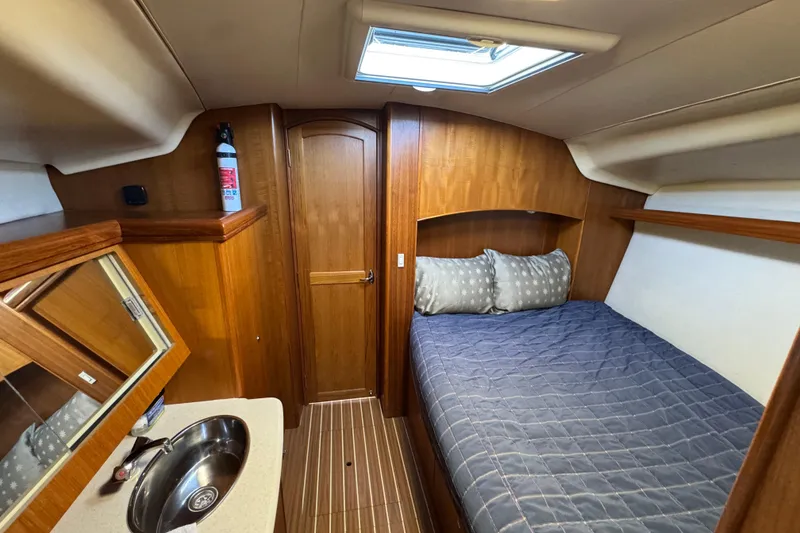 Slide: The Image of 2004 Hunter 41 Aft Cockpit cabin interior with bed, sink, and wooden finishes. - 51