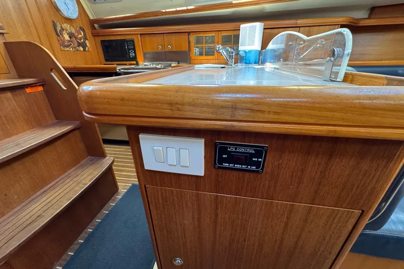 Slide: The Image of Interior of 2004 Hunter 41 Aft Cockpit yacht with wooden cabinetry and LPG control panel. - 54