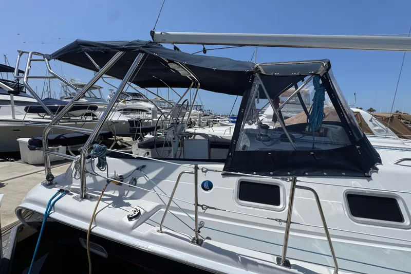 Slide: The Image of 2004 Hunter 41 Aft Cockpit sailboat docked at marina under clear blue sky. - 6