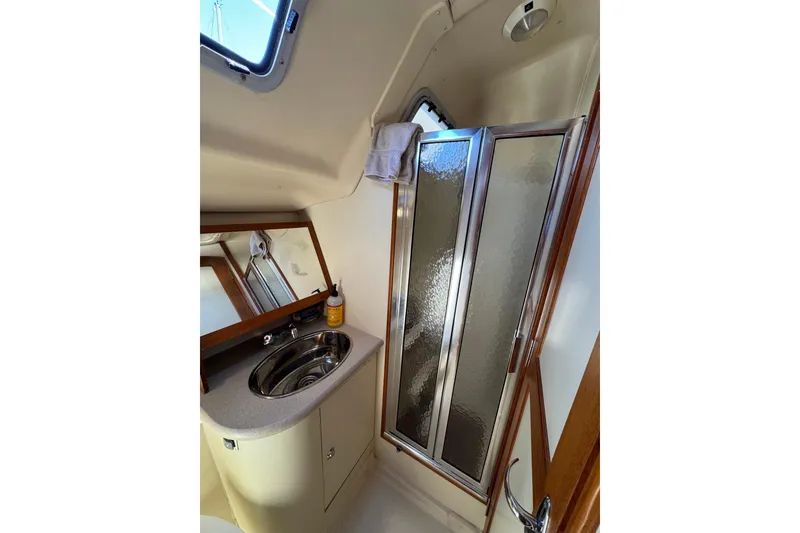 Slide: The Image of 2004 Hunter 41 Aft Cockpit yacht bathroom with sink, mirror, and shower. - 63