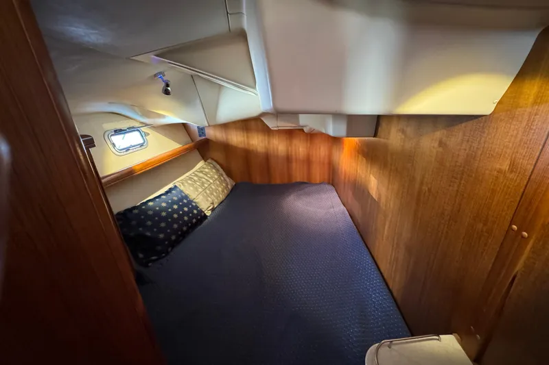 Slide: The Image of Cozy cabin interior of 2004 Hunter 41 Aft Cockpit sailboat with wooden paneling and bedding. - 66