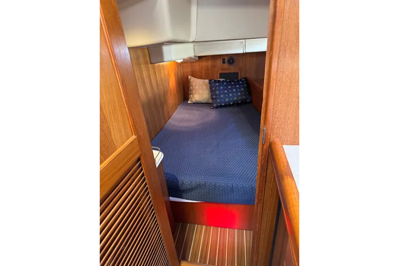 Slide: The Image of Cozy cabin interior of 2004 Hunter 41 Aft Cockpit sailboat with wooden paneling and bedding. - 70