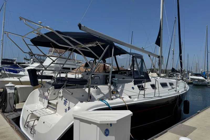 Slide: The Image of 2004 Hunter 41 Aft Cockpit sailboat docked at marina under clear blue sky. - 8