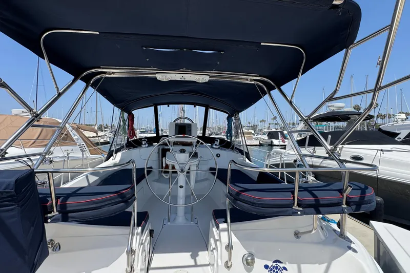 Slide: The Image of 2004 Hunter 41 Aft Cockpit sailboat interior with steering wheel, docked at marina. - 9