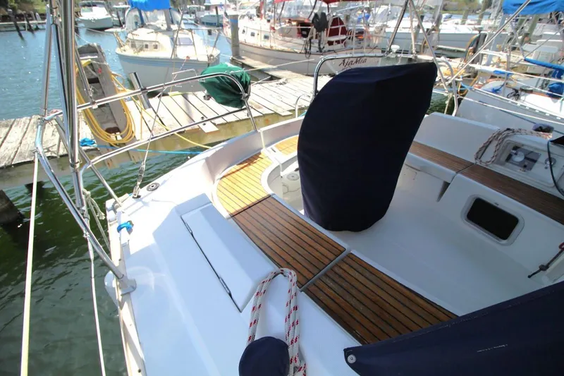 Slide: The Image of 2004 Jeanneau Sun Odyssey 35 sailboat cockpit with wooden deck, docked at marina. - 12